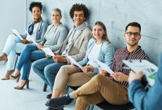 Group of young business people sitting in chairs and waiting for an interview